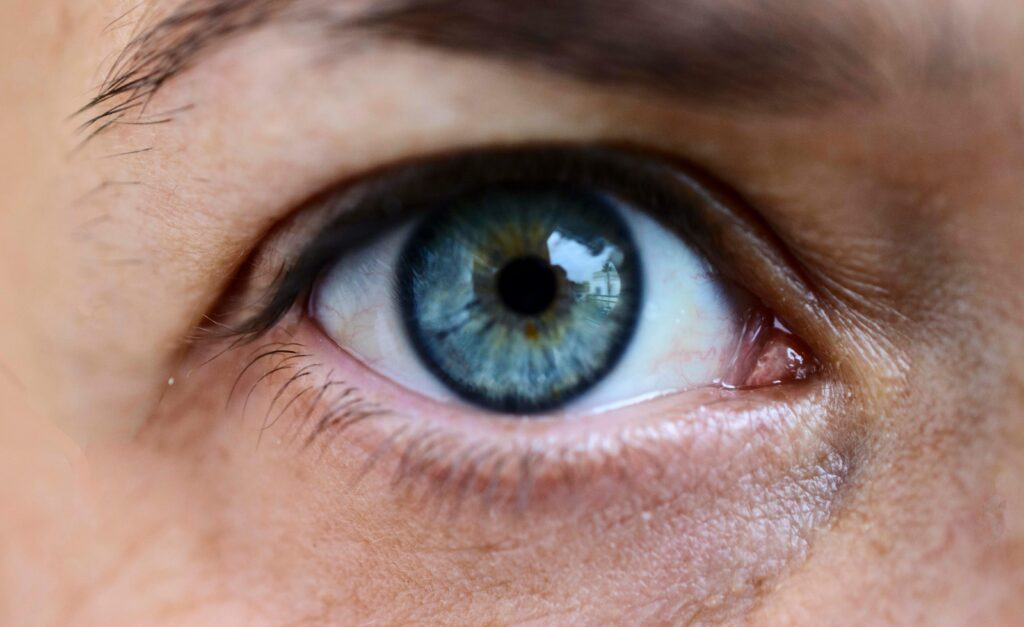 Close-up of a blue eye showing detailed iris patterns, suitable for optometry and vision themes.